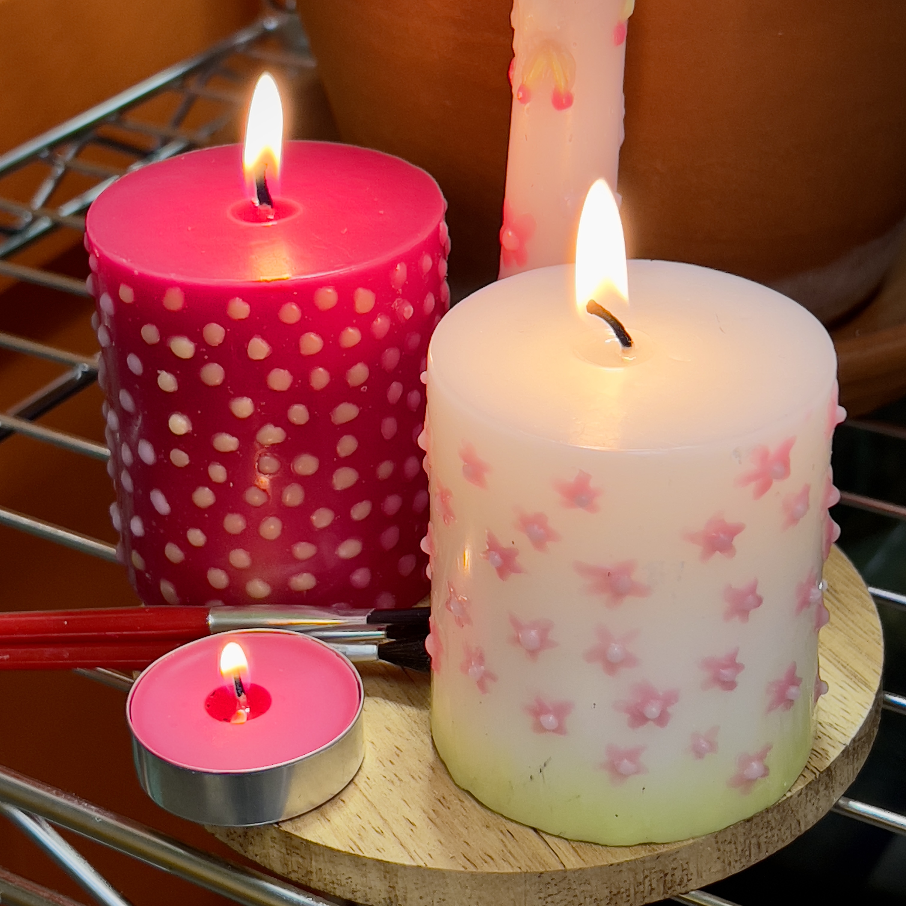 red white short candles with wax flowers painted on them, red tea light, white taper candle with wax flowers painted on it
