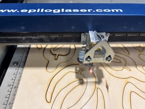 Epilog laser machine cutting shapes on wood