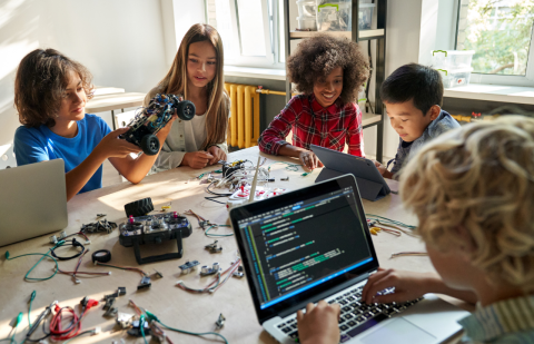 children with laptops and robots coding