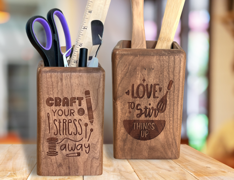 Two wood box containers left engraved with Craft your stress away, has scissors, ruler, cricut tools in it. Container on the right has I like to stir things up engraved on it with two wooden spoons in it
