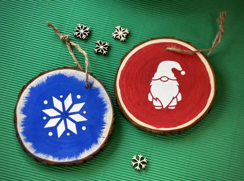 round wood slice ornaments painted blue with white snowflake and red with white gnome