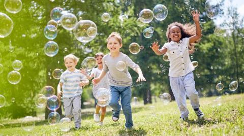 Children running outside with bubbles.