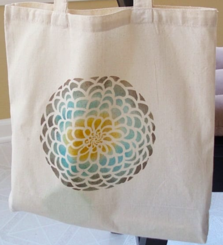 beige tote bag with stenciled design painted on it