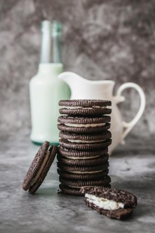 Image of stacked Oreo cookies in front of a glass of milk.