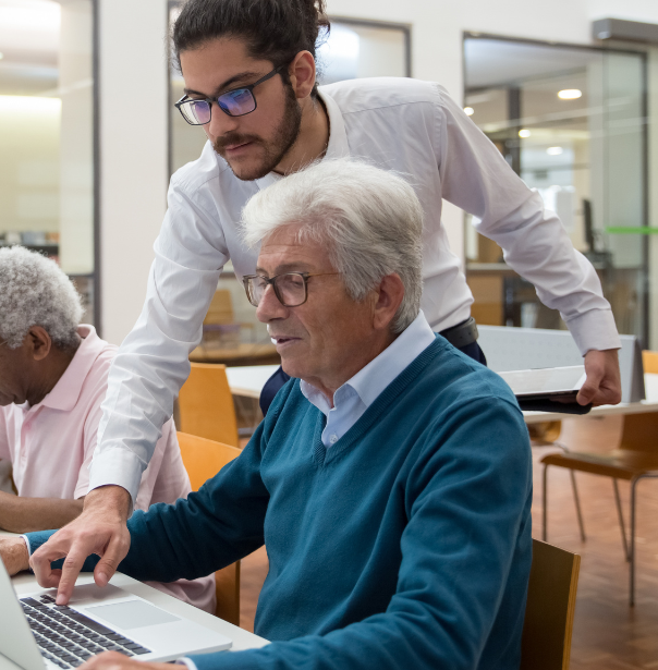 Tutor working with older adult on laptop