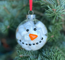 round clear ornament with marshmallows in it with a painted on snowman face